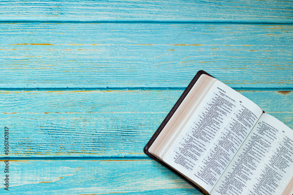 Open Holy Bible Book on a blue wooden table background with copy ...