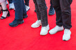 Feet of prom guests standing on a red carpet