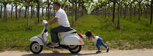 Nice Image Of A Little Girl Pushing A Motorcycle With Her Dad Who Ran Out Of Gas. Reference To Expensive Fuel. Horizontal Banner 