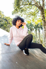 Wall Mural - beautiful afro teen female model in sportswear posing in park outdoors