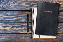 Holy Bible With Note Book And Pencil On Table For Christian Devotion