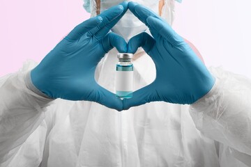 Sticker - The shape of heart made from hands in gloves holding the covid vaccine shot