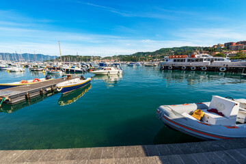 Wall Mural - Ferry boat station to the Cinque Terre in the port of the small Lerici town, with large group of small boats moored. Tourist resort on the coast of the Gulf of La Spezia, Liguria, Italy, Europe.