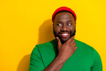 Wall Mural - Portrait of attractive sly cheery guy touching chin making decision copy space isolated over bright yellow color background