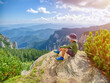 © Daniel CHETRONI - Happy boy hiking in mountains, conquers the summit in summer sunny day
