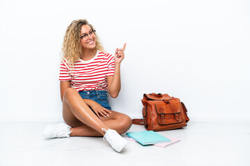 Wall Mural - Young student woman sitting one the floor pointing finger to the side