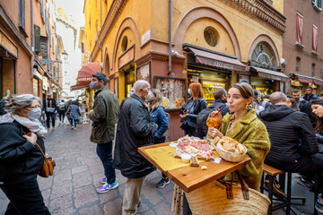 Wall Mural - Woman eating italian meat appetizer, various sliced meat and cheese with bread and Aperol Spritz at bar or restaurant outdoors. Concept of Italian lifestyle and gastronomy