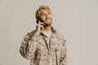 White military man wearing uniform smiling and talking on cellphone