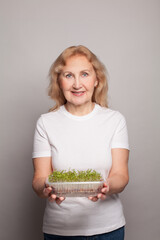 Wall Mural - Smiling mature woman with microgreen seeds