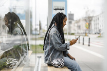 Young Woman Waiting For A Bus At A Bus Stop
