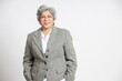 Happy confident mature senior indian business woman in a suit standing isolated on white background. smiling successful asian 60s gray-haired lady executive or business leader.