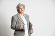 © GAJENDRRA BHATI  - Happy confident senior indian business woman holding coffee mug  against white background. asian lawyer legal 60s gray-haired person. finance, occupation, Ceo, Company. Executive.