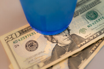 2 twenty dollar bills sit under the blue plastic cup, as payment for a meal, at a classic Diner in Upstate NY.