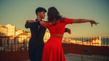 Beautiful Couple Dancing A Latin Dance Outside The City With Old Town In The Background. Sensual Dance By Two Professional Dancers On A Sunset In Ancient Culturally Rich Tourist Location.
