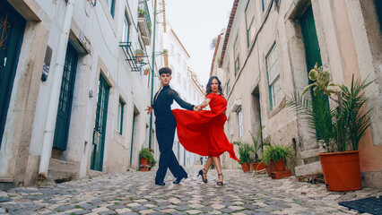 Wall Mural - Beautiful Couple Dancing a Latin Dance on the Quiet Street of an Old Town in a City. Sensual Dance by Two Professional Dancers on a Sunny Day Outside in Ancient Culturally Rich Tourist Location.