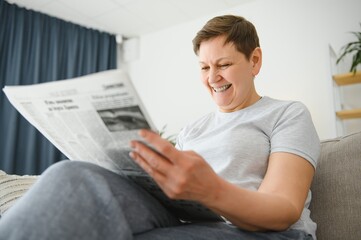 Canvas Print - woman reading newspaper at home