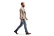 Full length profile shot of a man in a beige suit and jeans walking