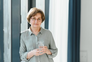 Sticker - Elderly woman holding glass of water. Concept of retirement