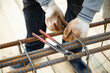 man cutting reinforcement mesh at building site