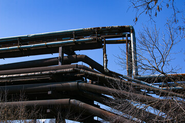 Wall Mural - Gas pipelines at a metallurgical plant against the blue sky. Concept of economic crisis. Ecology concept.