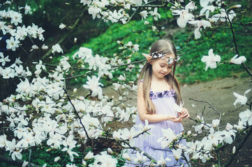 fairy tale girl. Portrait of mystic elf child. Cosplay character. Portrait of an elf in a blooming garden. A girl with long ears touches