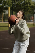 Girl Throws The Ball Into The Ring On The Basketball Court
