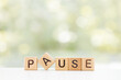 Wooden Blocks with the text: Pause on a green background