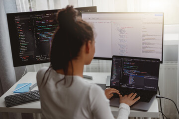 back view of woman coding on computer, professional female programmer working in room