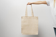 Female Hand Holding Eco Or Reusable Shopping Bag Against White Background