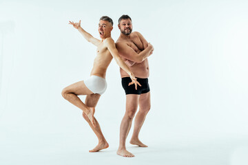two multiethnic men posing for a male edition body positive beauty set. shirtless guys with differen