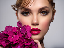 Beautiful White Girl With Purple Flowers. Stunning Brunette Girl With Big Violet Bouquet Flowers. Closeup Face Of Young Beautiful Woman With A Healthy Clean Skin. Pretty Woman With Bright Makeup