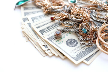 Many expensive golden and silver jewerly rings, earrings and necklaces with big amount of US dollar bills on white background. Pawnshop or jewerly shop