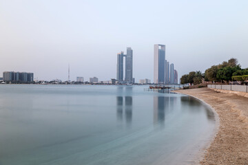 Wall Mural - Abu Dhabi skyline early morning. Establishing shot from the beach side.