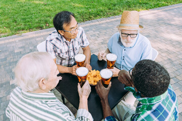 Wall Mural - Group of senior friends drinking a beer at the park