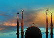 Eid Mubarak. Sunset over mosque. Muslim religion. Domes of mosque on background of sky. Eid Mubarak holiday. Religion Islam. Eid al-Adha celebration. Muslim holy Ramadan. Arab mosque minarets