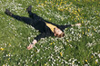 © Girts - Young man laying in green grass with flowers. People fatigue from work. Summer sleeping and relaxation techniques. Vitamin D sunbathing. Man power nap with eye closed. Rest after work from home