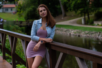 Fashion model posing outside in mini dress and jeans jacket. 