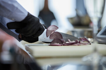 The cook cuts the onion. Cooking process. 