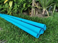 Blue PVC Pipes Piled Up On The Lawn