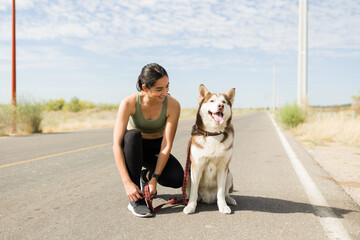 Smiling woman preparing for a run with her dog