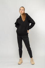 Wall Mural - Girl in black cargo pants and black hoodie isolated on white