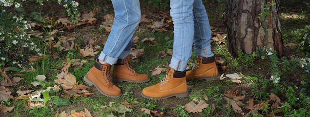 Men's and women's boots. Man and woman with winter boots side by side in the park.