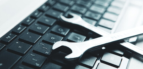 electronic technical support concept. wrenches on a computer keyboard.