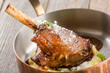 Juicy roasted duck leg with mashed potatoes in a serving frying pan.