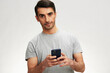 © SHOTPRIME STUDIO - man in a gray t-shirt with a phone communication technology isolated background