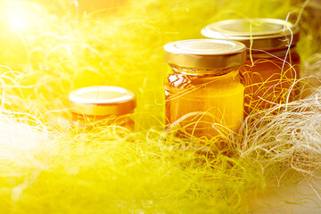 Wall Mural - Selective focus. Linden honey in a jar. Leaves and flowers of linden. Freshly linden honey.