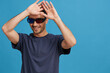 © SHOTPRIME STUDIO - portrait man in blue t-shirt 3d glasses entertainment gesture with hands isolated background
