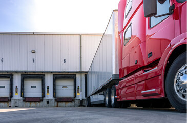 red modern american semi truck parked at the docks, waiting to get loaded. shipping and receiving, t