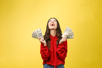 Wall Mural - Closeup of young beautiful woman with us dollar money in hand over yellow background, with copy space