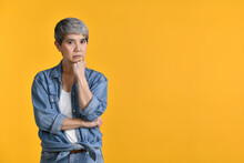 Image Of Worried, Thinking Middle Aged Asian Woman 50s Standing Isolated Over Colour Background, Looking At Camera.